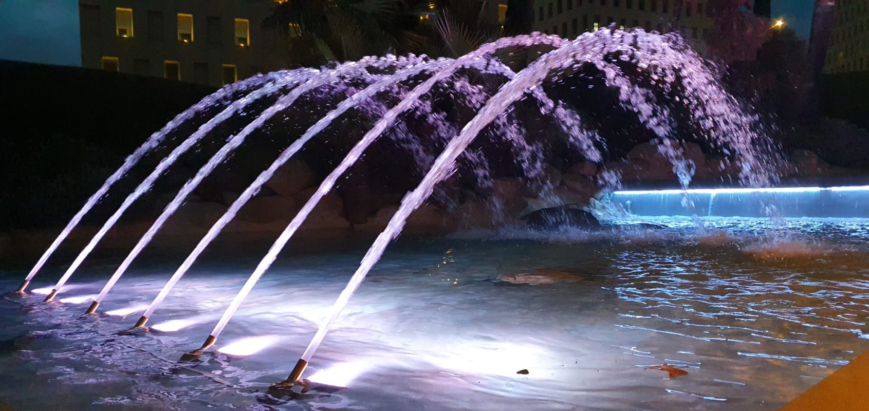 Fountain water jets tracing parabolic projectile-motion arcs