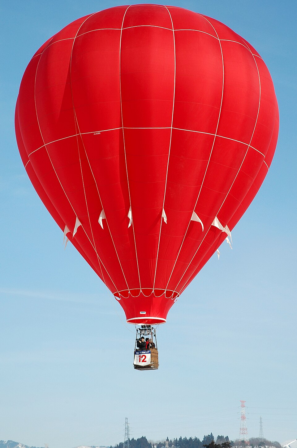 Hot-air balloon envelope heated by a burner, an everyday example of the ideal gas law lowering air density