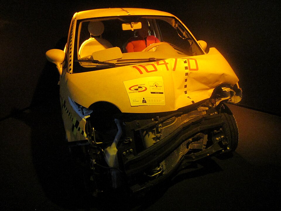 Crash-tested Fiat 500 with a crumpled front end, an inelastic collision that converts kinetic energy into bent metal