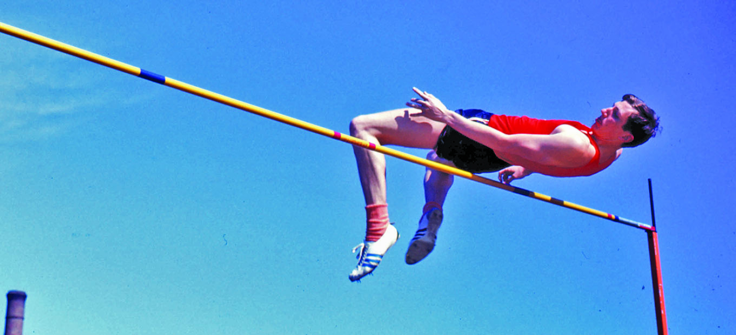 High jumper arched over the bar with the center of mass passing below it