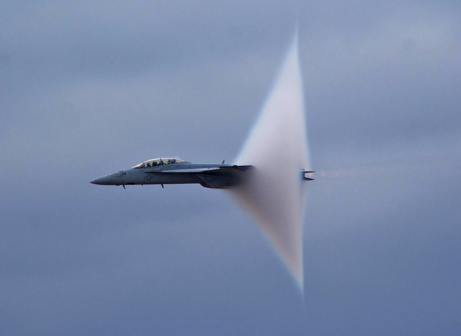 Jet aircraft near the speed of sound with a visible vapour cone