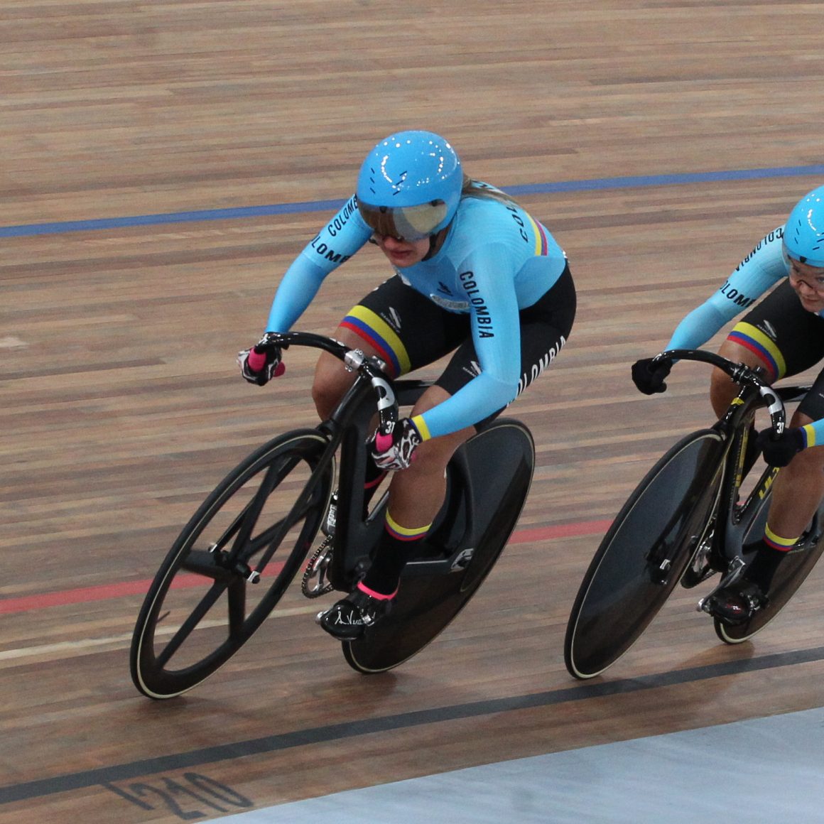 Steeply banked curve on a velodrome track showing the banking angle used in tanθ = v²/rg
