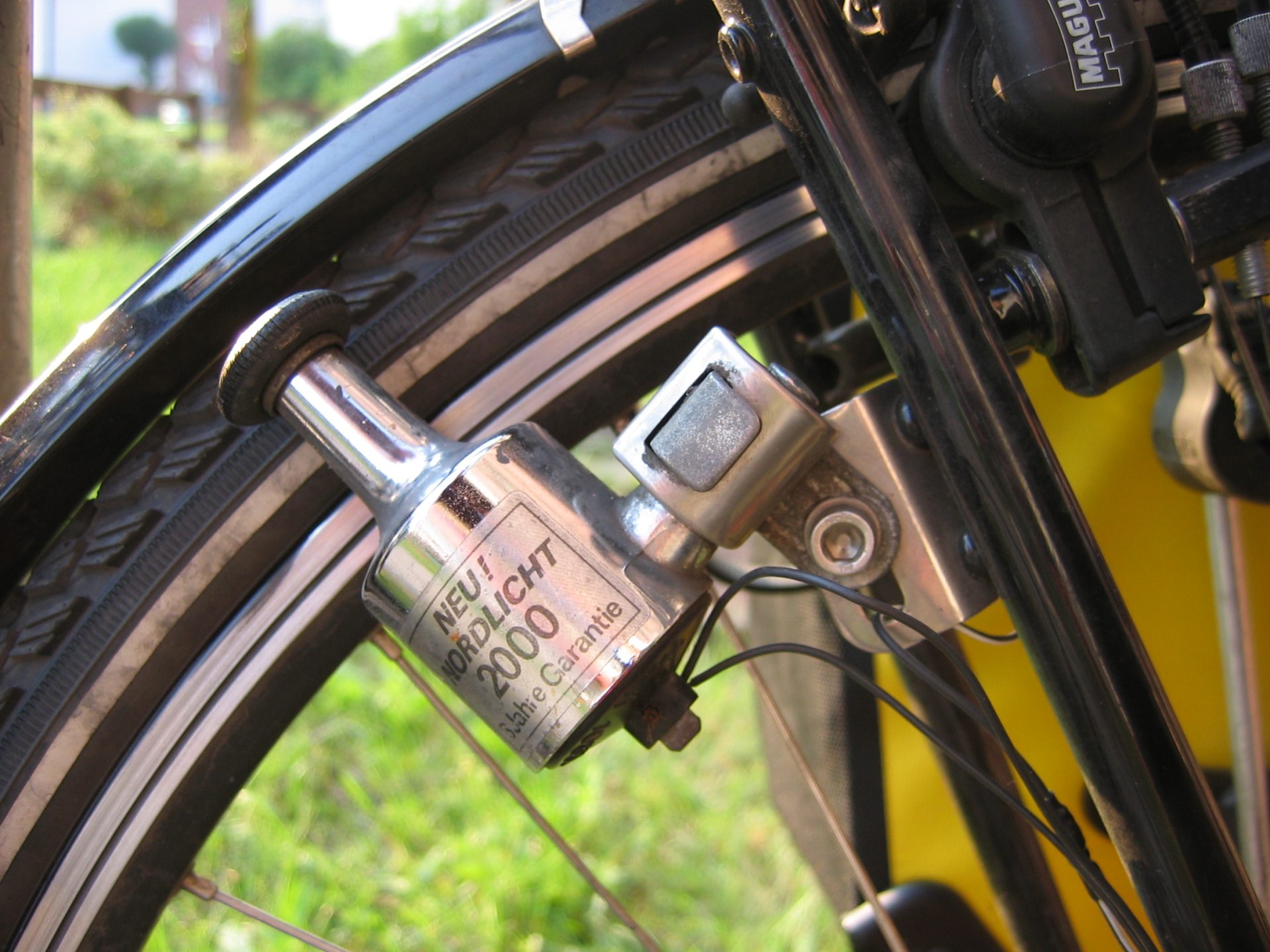 Bicycle bottle dynamo pressed against a wheel, an everyday example of Lenz's law making the wheel harder to turn